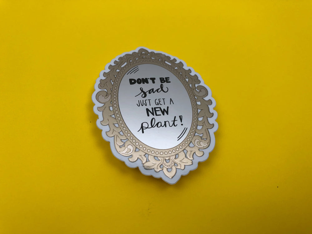 Decorative sticker with text 'Don't be sad, just get a new plant!' on a yellow background