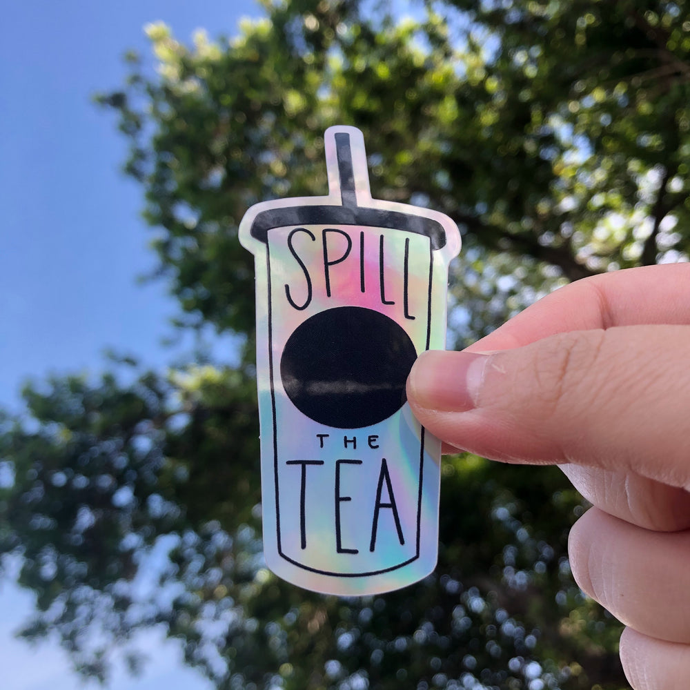 Sticker in the shape of a cup with lid and straw that says 'Spill The Tea" with trees and sky in the background