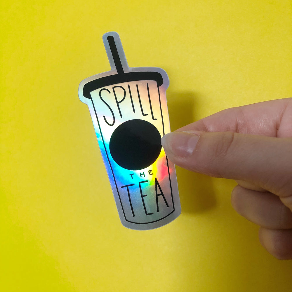 Sticker in the shape of a cup with lid and straw that says 'Spill The Tea" on a yellow background